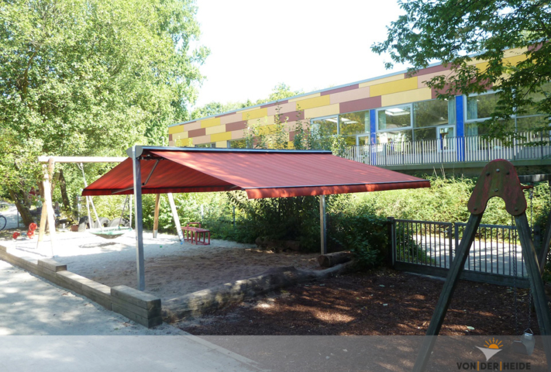 Tandemmarkise auf Ständern über Sandkiste einer Kita