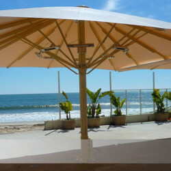 Bahama-Jumbrella XL Großschirm am Strand Windstabiler Sonnenschirm quadratisch. Bahama-Jumbrella XL Großschirm am Meer, Farbe beige mit Heizungen und Regenrinne