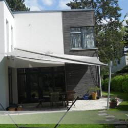 Design-Sonnensegel an kubischem Haus Rollup Sonnensegel an einem kubischen Haus mit WDVS und Holz