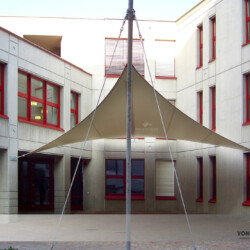 Ganzjahressegel in Innenhof Ganzjahressegel mit Wandbefestigung und Mast in einem Innenhof