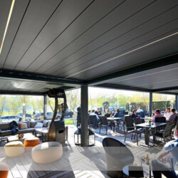 Lamellendach in Restaurant (geschlossene Lamellen) Mehrere Lamellendächer als Sonnen- und Regenschutz einer Restaurant-Terrasse