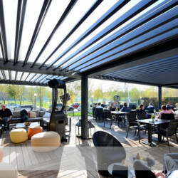 Lamellendach in Restaurant (geöffnete Lamellen) Mehrere Lamellendächer als Sonnen- und Regenschutz einer Restaurant-Terrasse