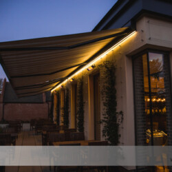 Kassettenmarkise mit Beleuchtung Gekoppelte Dreifach-Kassettenmarkise mit Beleuchtung in einem Restaurant