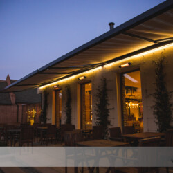 Gekoppelte Kassettenmarkisen Gekoppelte Dreifach-Kassettenmarkise mit Beleuchtung in einem Restaurant