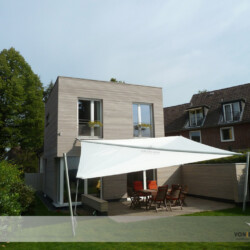 Sonnensegel mit Höhenverstellung Motorisches Sonnensegel Soliday-C an moderndem Holzhaus mit Höhenverstellung