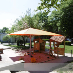 Oranger Sonnenschirm in Sandkiste Windstabiler Profi-Schirm in einer Kita in Hamburg