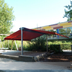 Kita-Tandemmarkise Farbe rot Tandem- oder Doppelmarkise mit rotem Tuch in einer Sandkiste eines Kindergartens. Markisen je 6x3m = gesamt 36 Quadratmeter
