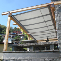 SHADESIGN-structure unter Holz-Pergola / Seitenansicht Ein SHADESIGN-structure Markisen-Segel unter einer Holzpergola auf einem Balkon