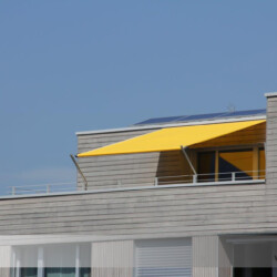 Markisensegel-Shadesign-Inox-Twister in gelb auf Dachterrasse Gelbes Markisensegel Modell "Shadesign-inox" (früher Twistersegel) auf einer Dachterrasse