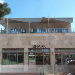 Motorisch aufrollbares Markisensegel Soliday-CS auf Restaurant-Balkon - Frontalansicht Motorisch aufrollbares Markisensegel Soliday-CS auf Balkon am AHOI in Scharbeutz bietet Sonnen- und Regenschutz und ein tolles Design