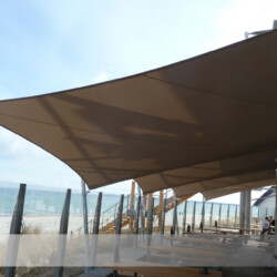 Meerblick unter Sonnensegeln Die vier Saisonsegel schützen bei Wind und Wetter. Textile Architektur am AHOI Steffen Henssler in Scharbeutz