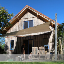 Saisonsegel an Holzhaus Festverspanntes Segel für die Sommersaison an Holzhaus und Alumasten