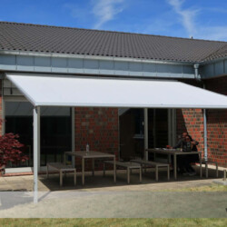 Pergola-Markise-Markilux - Frontalansicht Pergola-Markise-Markilux 110 als sonnen- und Regenschutz über einem Aufenthaltsbereich eines Gewerbebetriebes