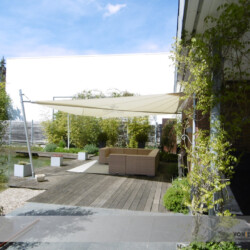 Sonnensegel an Terrasse mit Natur-Schwimmteich - Seitenansicht Aufrollbares Sonnensegel an Terrasse mit Natur-Schwimmteich