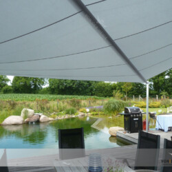 Sonnensegel an Schwimmteich Diagonalwellen-Segel Soliday-C auf Bankirai-Terrasse mit Blick auf Schwimmteich nähe Kiel