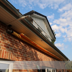 Eingerolltes Markisen-Segel Unter dem Dachüberstand ist die Tuchwelle automatisch vor Verschmutzung geschützt.