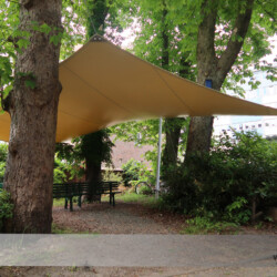 Aufenthaltsbereich geschützt unter einem Sonnensegel Diese Hamburger Einrichtung bietet Arbeits- und Ausbildungsplätze für Menschen mit Behinderung und geschützte Aufenthaltsbereiche im Freien.