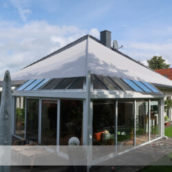 Perfekte Wintergartenbeschattung mittels Diagonalwellensegel Dieses automatisierte aufrollbare Sonnensegel schützt den Wintergarten gegen Aufheizung.